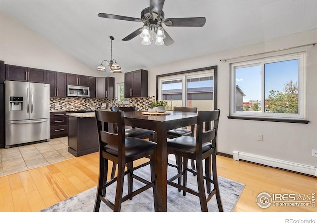 dining area featuring light wood finished floors, a baseboard radiator, vaulted ceiling, and ceiling fan