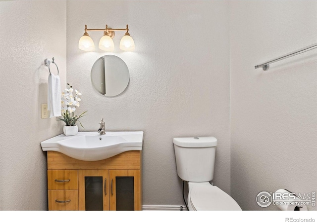 half bathroom with vanity and toilet