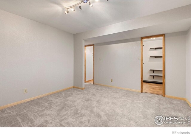 unfurnished room featuring carpet flooring and baseboards