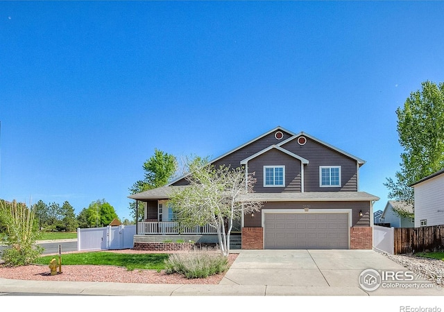 3530 Homestead Dr, Mead, CO 80542 - view of front of house featuring brick siding, concrete driveway, covered porch, a garage, and fence