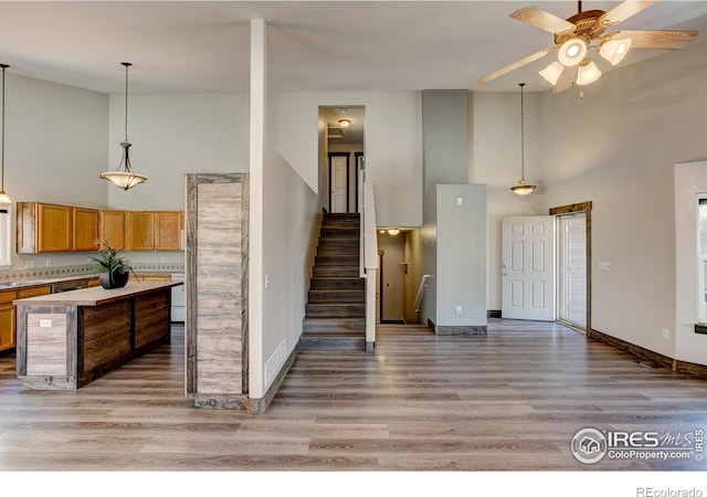 3530 Homestead Dr, Mead, CO 80542 - kitchen with high vaulted ceiling, light countertops, brown cabinetry, a ceiling fan, and light wood-type flooring