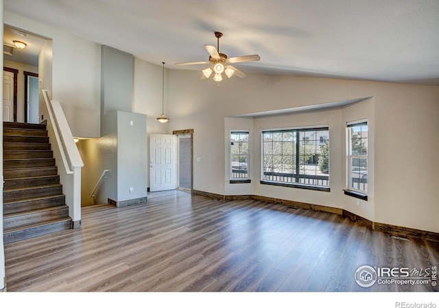 3530 Homestead Dr, Mead, CO 80542 - unfurnished living room featuring wood finished floors, ceiling fan, stairs, baseboards, and high vaulted ceiling