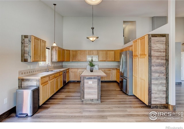 3530 Homestead Dr, Mead, CO 80542 - kitchen featuring stainless steel appliances, a sink, high vaulted ceiling, a center island, and light brown cabinets