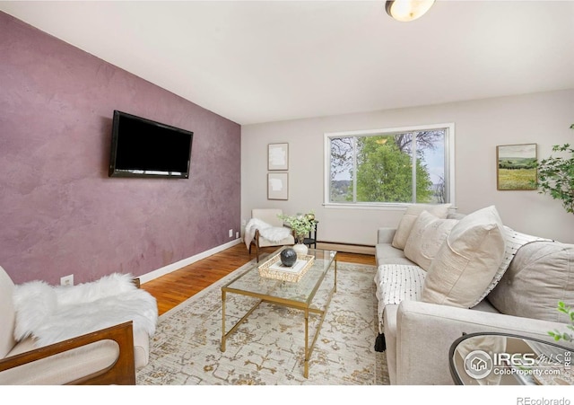 living area with wood finished floors, baseboards, and baseboard heating