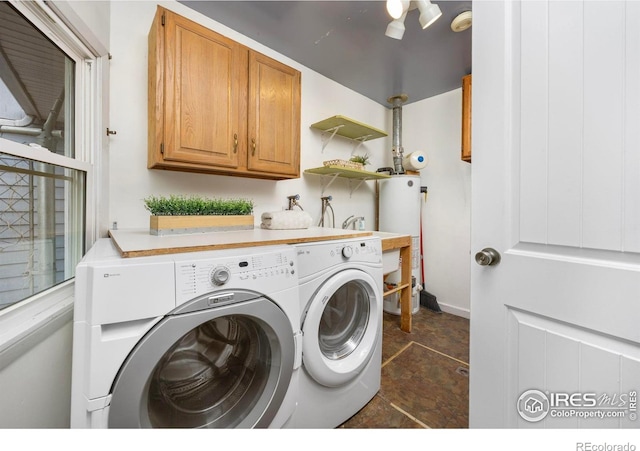 laundry area with washing machine and dryer, cabinet space, and water heater