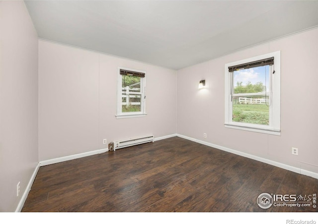 empty room featuring baseboard heating, dark wood-type flooring, and baseboards