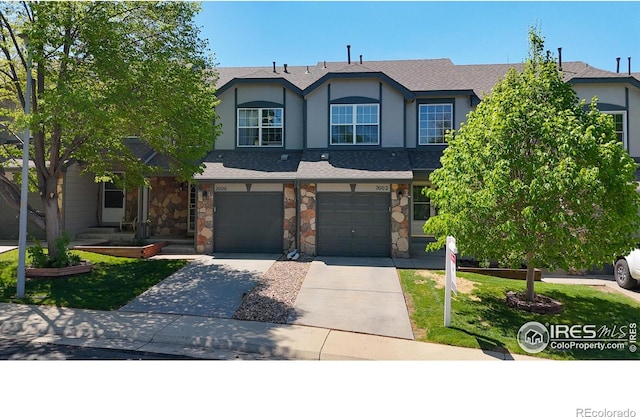 2002 E 102nd Cir, Thornton, CO 80229 - view of front of house featuring driveway, an attached garage, stucco siding, and stone siding