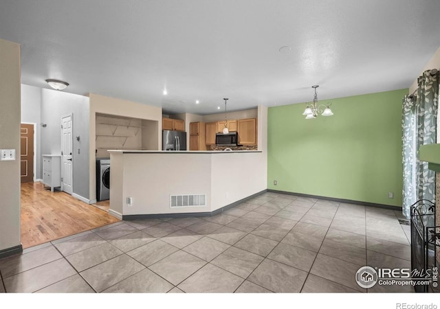 2002 E 102nd Cir, Thornton, CO 80229 - kitchen with appliances with stainless steel finishes, light tile patterned flooring, a chandelier, a peninsula, and baseboards
