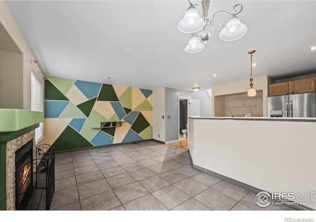 2002 E 102nd Cir, Thornton, CO 80229 - kitchen featuring stainless steel refrigerator with ice dispenser, a chandelier, a warm lit fireplace, decorative light fixtures, and light tile patterned floors