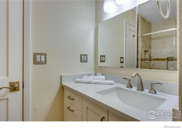 6300 Feldspar Ct, Bellvue, CO 80512 - full bathroom featuring a shower stall, vanity, and a textured wall