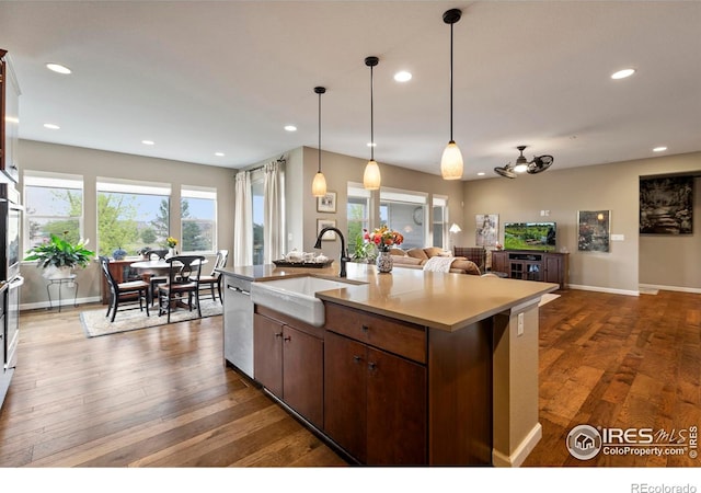 kitchen featuring a sink, open floor plan, stainless steel dishwasher, recessed lighting, and pendant lighting