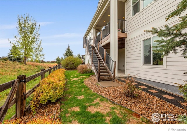 view of yard with fence and stairs