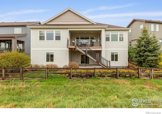 rear view of property featuring a fenced backyard and stairs