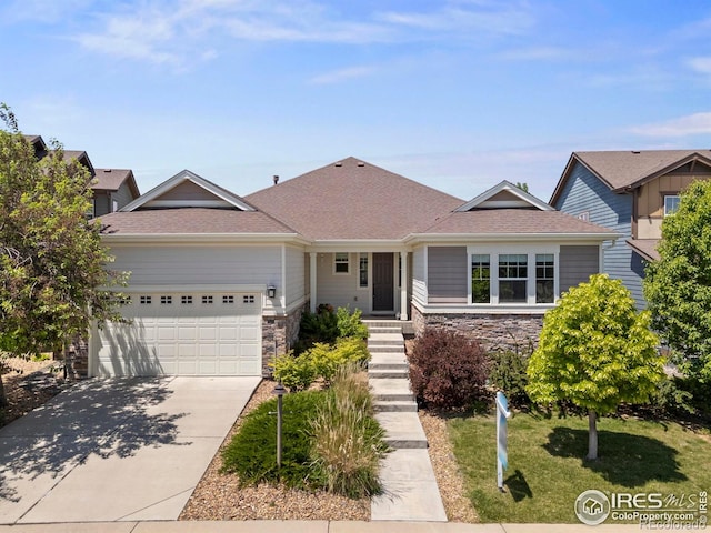 2551 Cub Lake Ct, Loveland, CO 80538 - ranch-style home featuring stone siding, a garage, concrete driveway, roof with shingles, and a front lawn