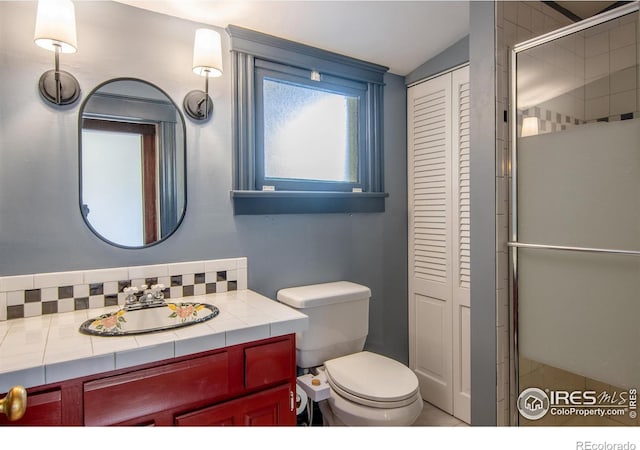 2645 5th St, Boulder, CO 80304 - full bathroom with a closet, toilet, vanity, vaulted ceiling, and backsplash