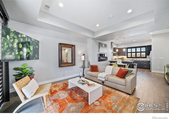 7861 W 51st Ave, Arvada, CO 80002 - living room featuring a raised ceiling, light wood-style flooring, and recessed lighting