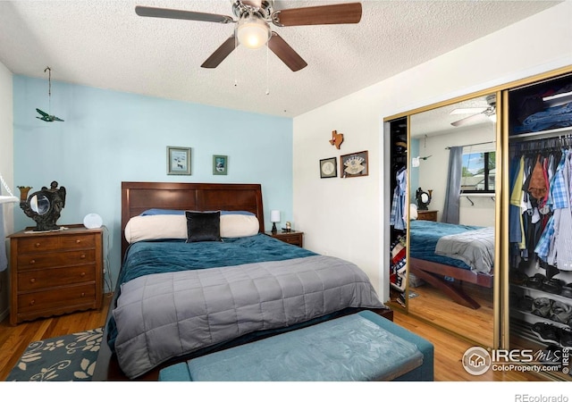 bedroom featuring a closet, wood finished floors, a textured ceiling, and ceiling fan