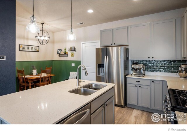 kitchen featuring a sink, stainless steel appliances, gray cabinetry, and recessed lighting