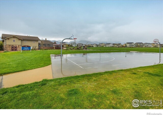 view of sport court featuring a residential view, a yard, and community basketball court