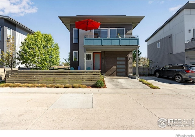 725 Amelia Ln, Lafayette, CO 80026 - contemporary home featuring a balcony, driveway, fence, and a garage