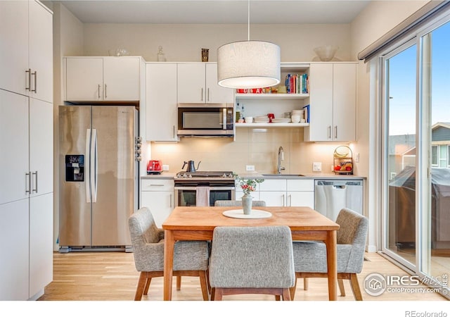 725 Amelia Ln, Lafayette, CO 80026 - kitchen featuring appliances with stainless steel finishes, a sink, light wood-type flooring, white cabinets, and light countertops