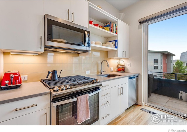 725 Amelia Ln, Lafayette, CO 80026 - kitchen featuring stainless steel appliances, a sink, healthy amount of natural light, and white cabinetry