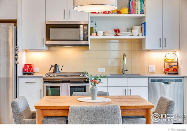725 Amelia Ln, Lafayette, CO 80026 - kitchen featuring appliances with stainless steel finishes, a sink, open shelves, and decorative backsplash