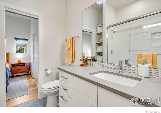 725 Amelia Ln, Lafayette, CO 80026 - ensuite bathroom with toilet, wood finished floors, vanity, and decorative backsplash