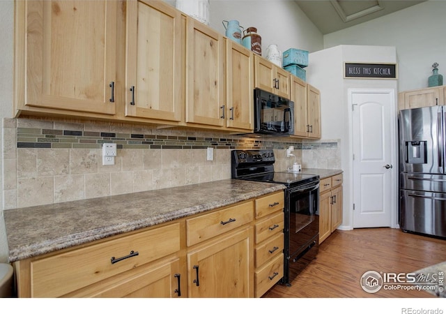 1318 Chamois Dr, Severance, CO 80550 - kitchen featuring black appliances, light brown cabinets, light wood-type flooring, tasteful backsplash, and vaulted ceiling