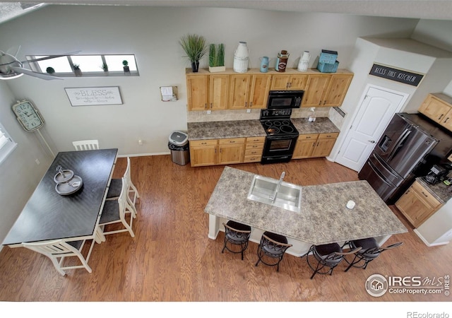 1318 Chamois Dr, Severance, CO 80550 - kitchen with black appliances, wood finished floors, and baseboards