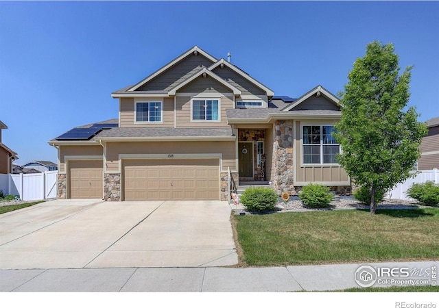 1318 Chamois Dr, Severance, CO 80550 - view of front facade featuring stone siding, solar panels, driveway, and a garage