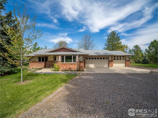 single story home with driveway, an attached garage, brick siding, and a front yard