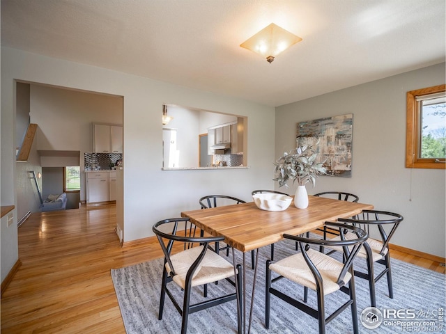 dining area featuring light wood finished floors and baseboards