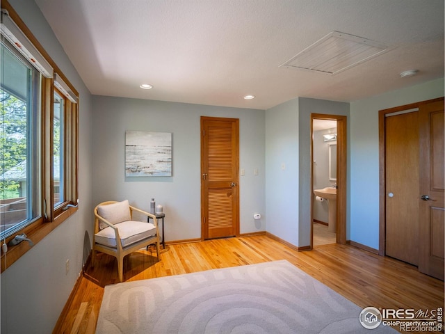 sitting room featuring light wood-style flooring, baseboards, and recessed lighting