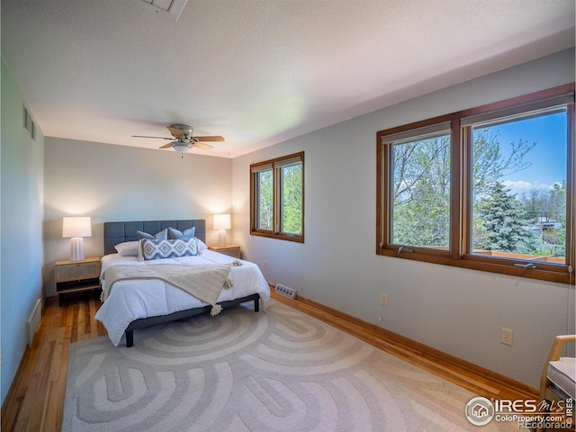 bedroom with wood finished floors, baseboards, and ceiling fan