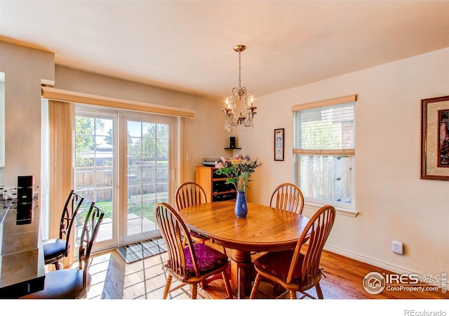 11656 Logan St, Northglenn, CO 80233 - dining room with plenty of natural light, light wood-style flooring, a chandelier, and baseboards