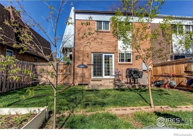 11656 Logan St, Northglenn, CO 80233 - back of house with brick siding, a gate, a patio area, and a vegetable garden