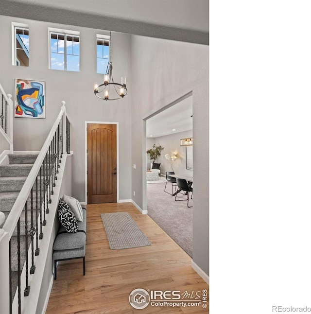 2458 Vale Way, Erie, CO 80516 - foyer entrance with a chandelier, stairway, wood finished floors, baseboards, and a high ceiling