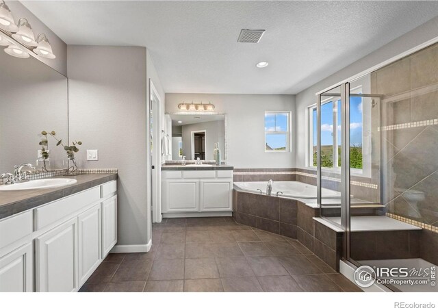 2458 Vale Way, Erie, CO 80516 - bathroom with a garden tub, tile patterned flooring, two vanities, recessed lighting, and a stall shower