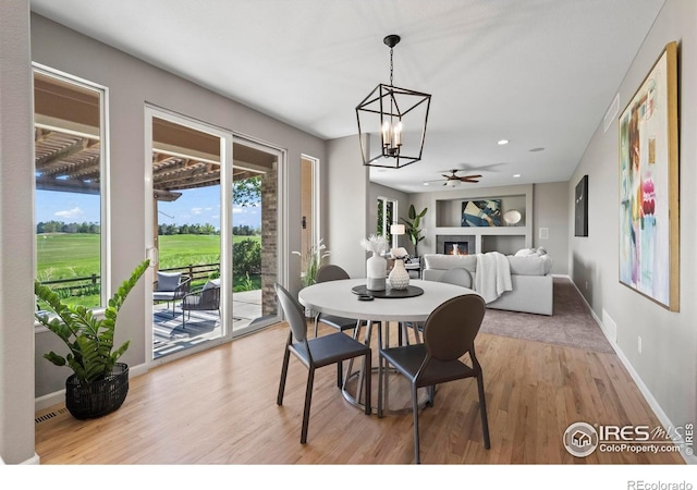 2458 Vale Way, Erie, CO 80516 - dining room with wood finished floors, a chandelier, ceiling fan, baseboards, and built in shelves