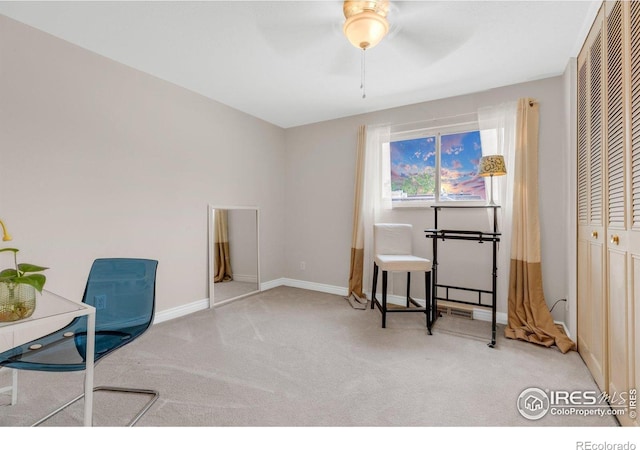 living area with carpet flooring, a ceiling fan, and baseboards
