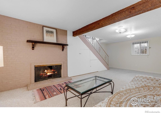 carpeted living room featuring stairway, a fireplace, beamed ceiling, brick wall, and baseboards