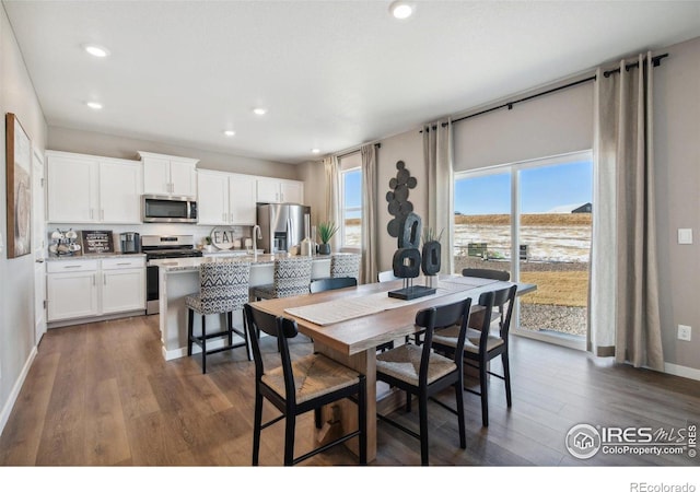 dining space with dark wood-style floors, baseboards, and recessed lighting
