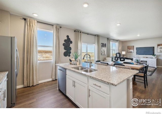 kitchen with stainless steel appliances, a sink, open floor plan, dark wood-style flooring, and recessed lighting