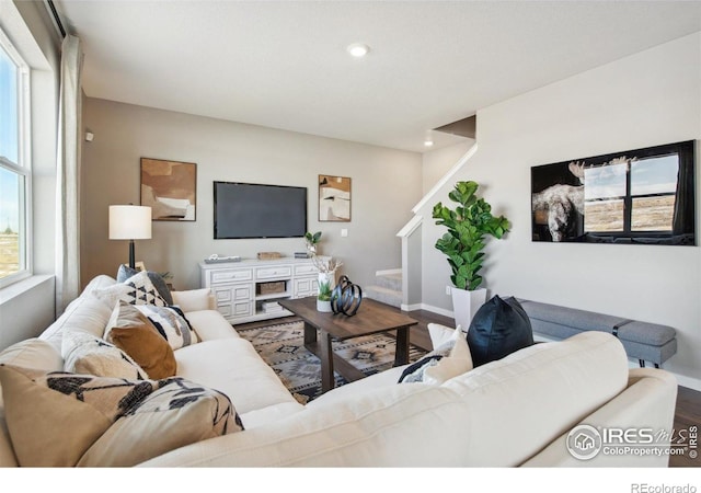 living area with wood finished floors, stairs, baseboards, and recessed lighting