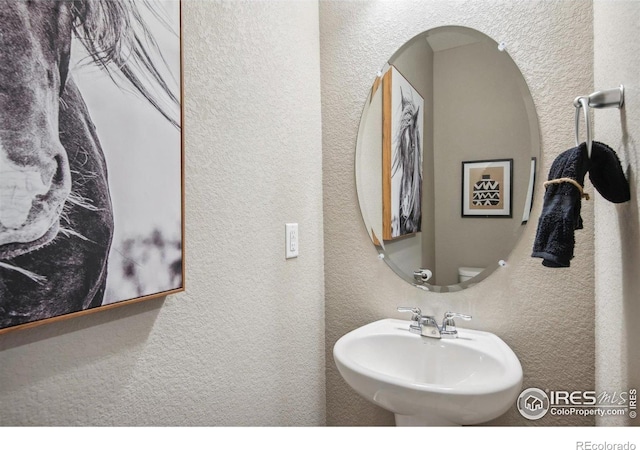 bathroom with a sink and a textured wall