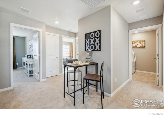 dining room featuring independent washer and dryer, light carpet, recessed lighting, and baseboards