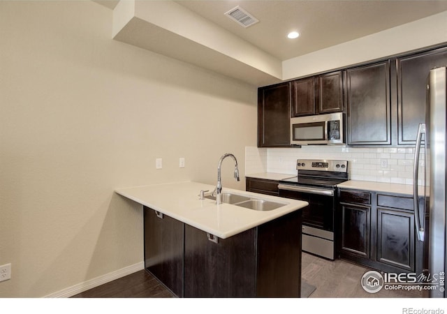 3051 County Fair Ln Unit 2, Fort Collins, CO 80528 - kitchen featuring appliances with stainless steel finishes, a sink, a peninsula, backsplash, and dark brown cabinets