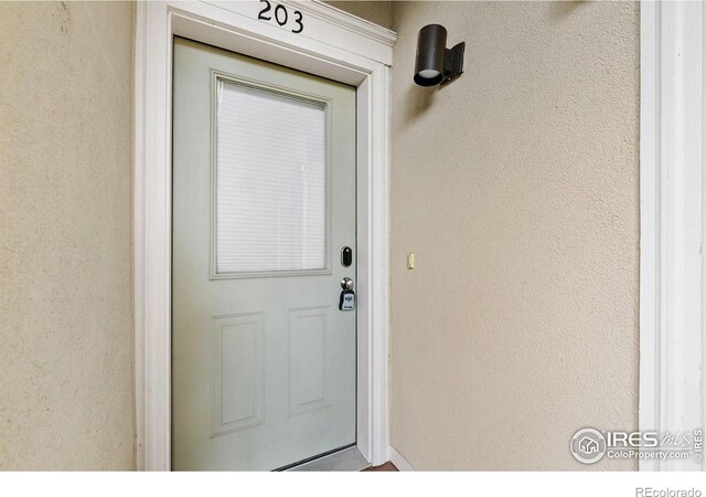 401 Mason Ct Unit 203, Fort Collins, CO 80524 - view of exterior entry featuring stucco siding