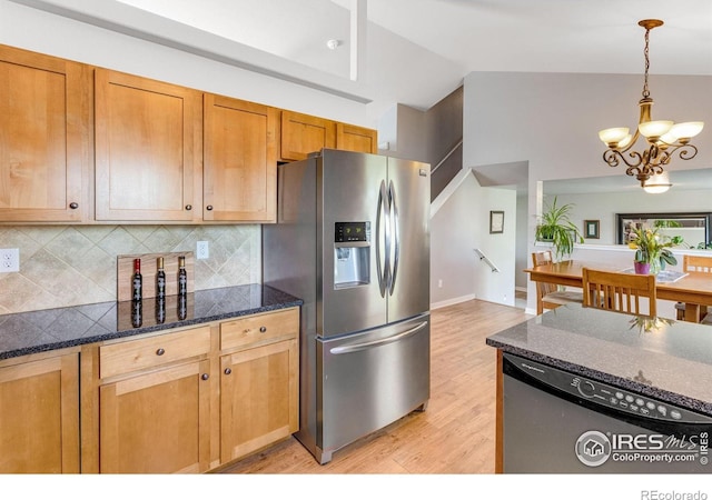 kitchen with appliances with stainless steel finishes, lofted ceiling, tasteful backsplash, a chandelier, and light wood-style flooring